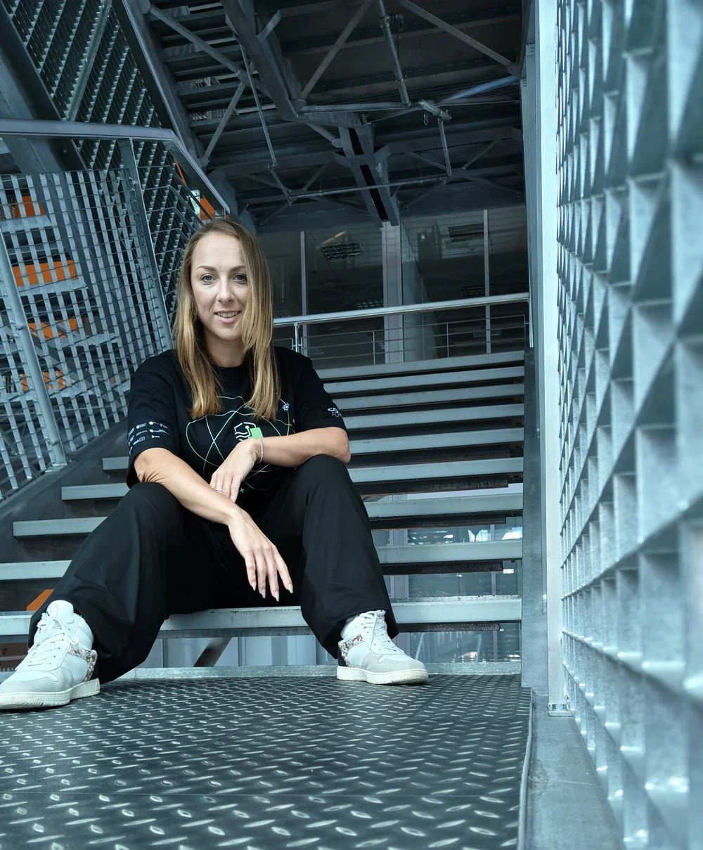 Olimpia Goździewicz siedząca na metalowych schodach w hali biblioteki