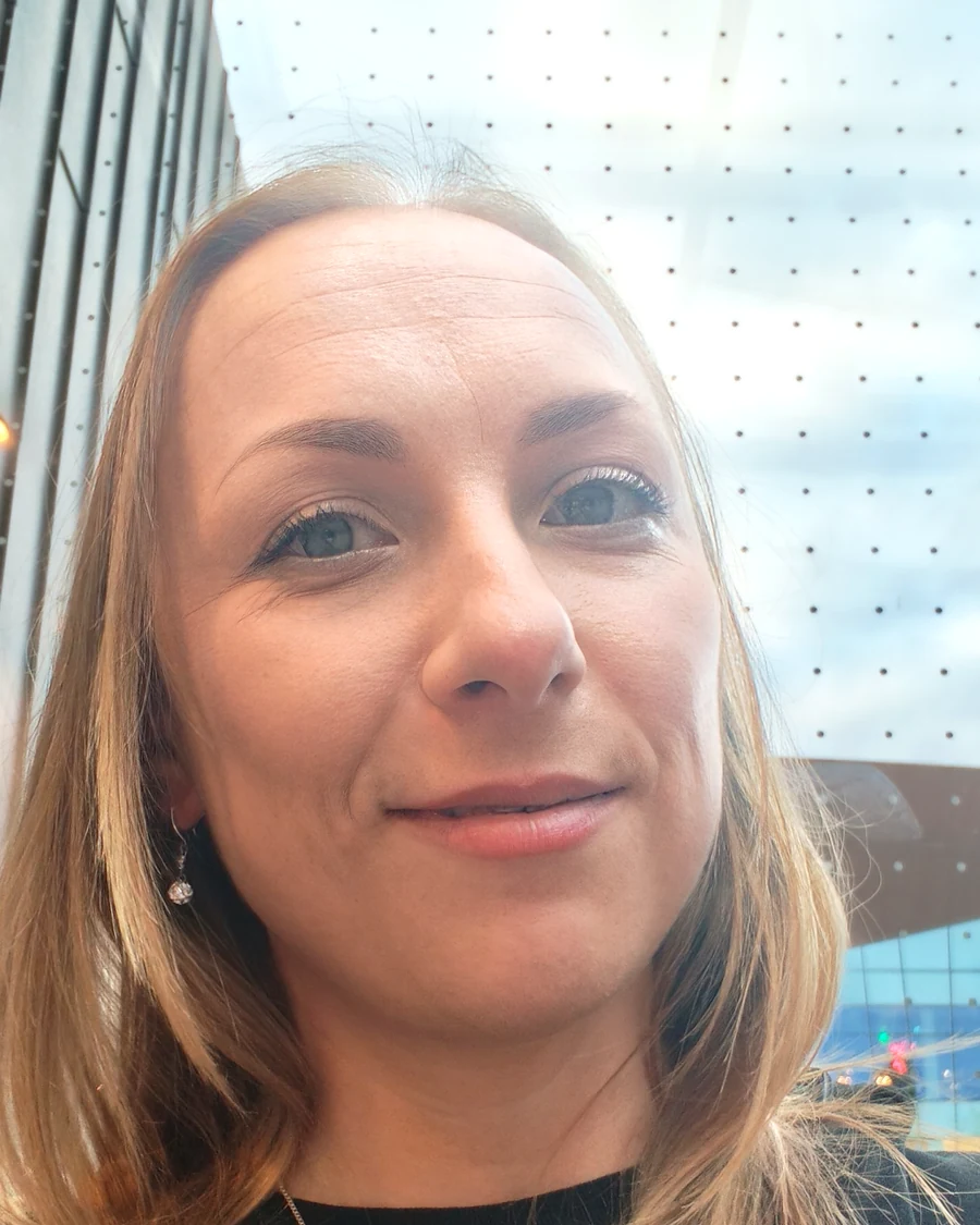 Portret Olimpii Goździewicz przy przeszklonej ścianie