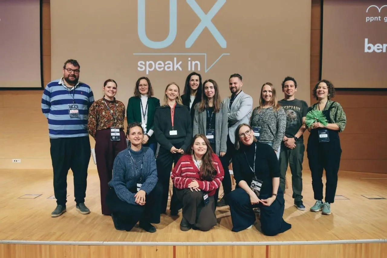 Uczestnicy maratonu obecni na prezentacji, na scenie pod napisem UX speak in